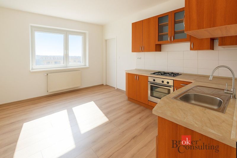 A kitchen with wooden decor and appliances in a 2-room apartment.