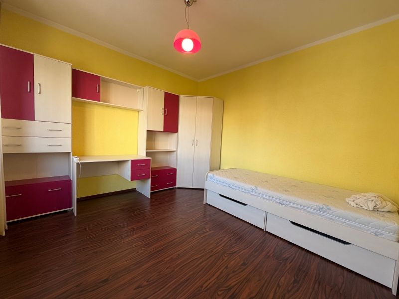 Children's room in a 3-room apartment with yellow walls and furniture with storage space.