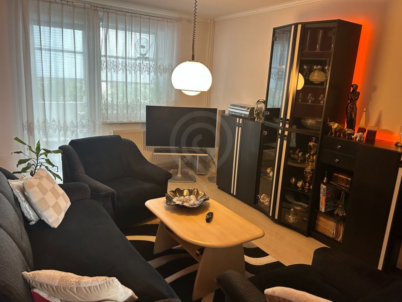 Living room in a 3-room apartment with comfortable seating and a floor lamp.