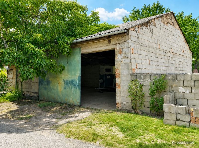 A family house in Illmitz has a brick garage with green doors and surrounding greenery.