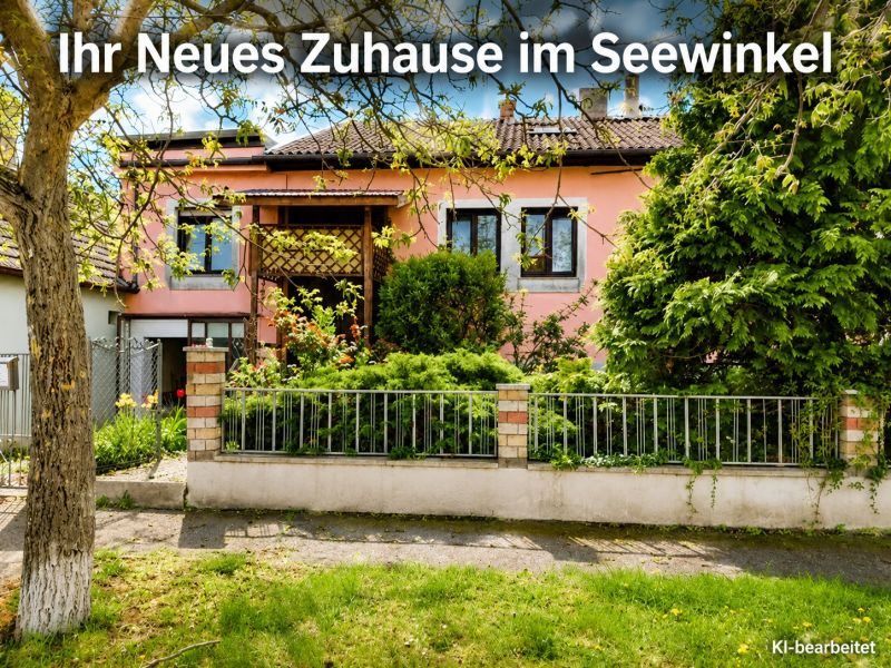 A family house in Illmitz with a pink facade and a green front garden full of plants.