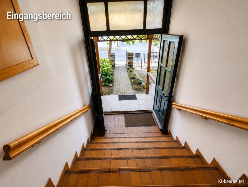 A staircase in a family house with a view of the garden through open doors.