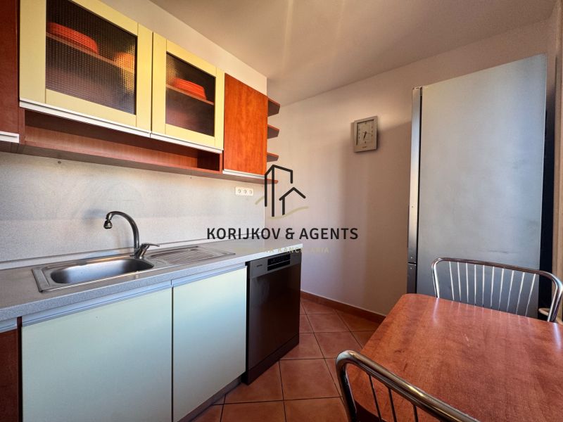 The kitchen of a 4-room apartment with a kitchen table, dishwasher, and cabinets with a wooden decor.