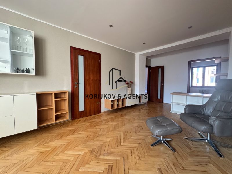 Living room with a sofa set and wood-patterned flooring in a 4-room apartment.