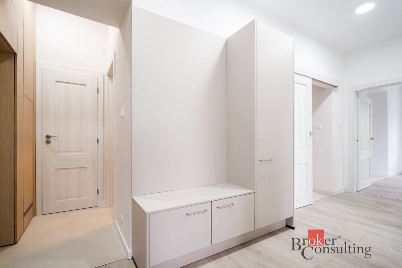 Entrance hall with white furniture in a 3-room apartment, floor with wood decor.