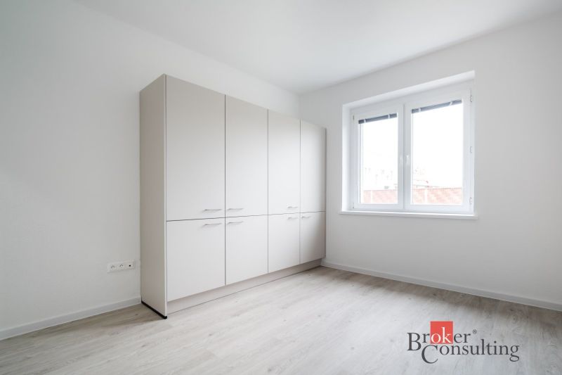 A bright room with a white wardrobe and a wood-patterned floor in a 3-room apartment.