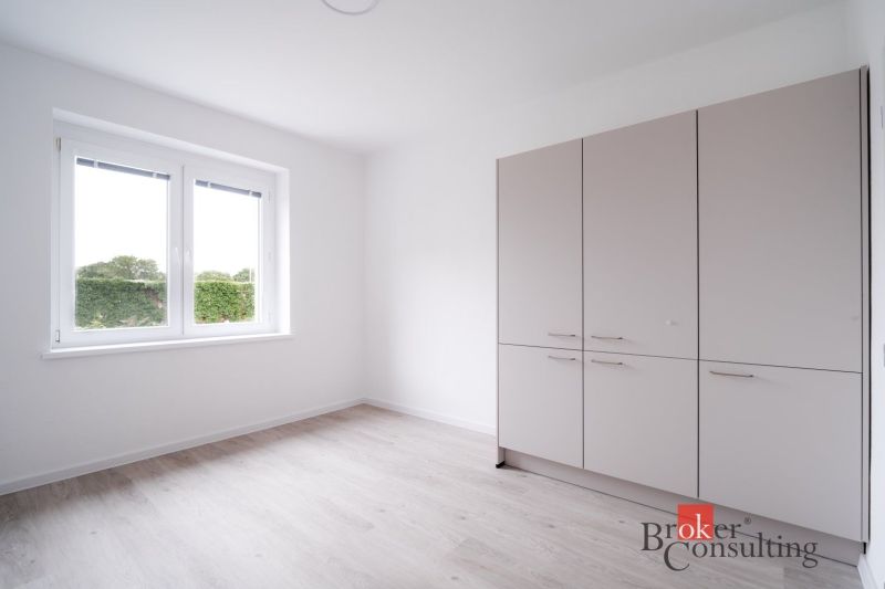 A room in a 3-room apartment with a wooden decor floor and a wardrobe.