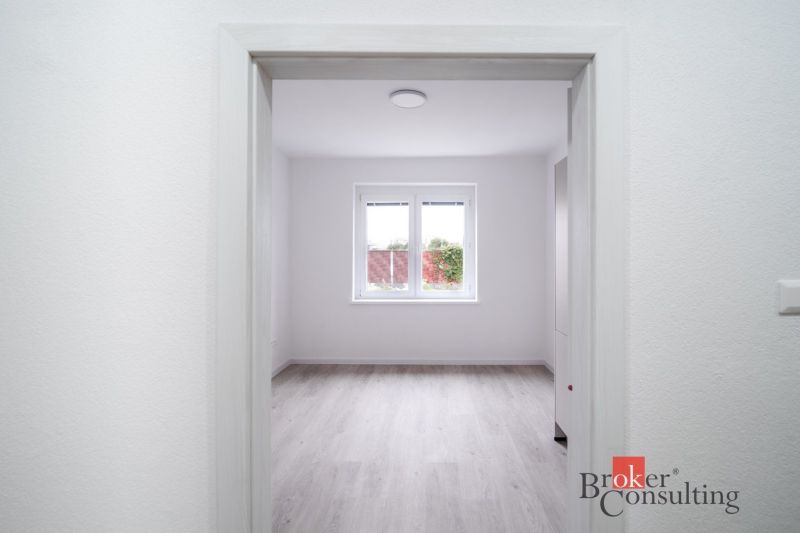 A spacious room with a wooden decor floor in a 3-room apartment.