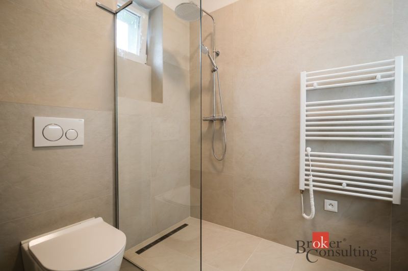 A shower corner with a toilet and a radiator in the bathroom of a 3-room apartment.