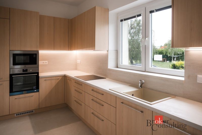 A kitchen in a 3-room apartment with wooden decor and modern appliances.