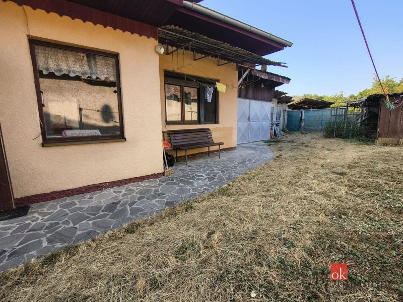 A family house in Ladice with a garden, a stone path, and a bench.