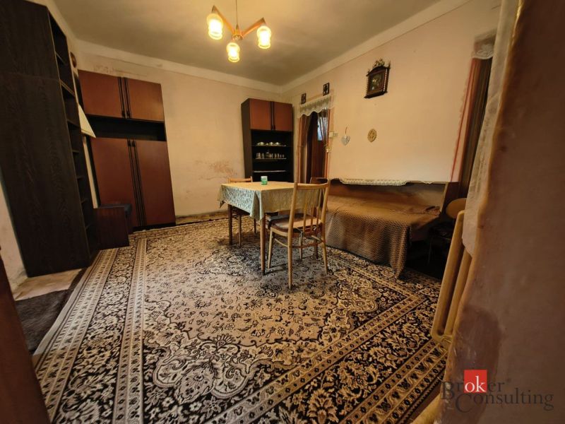 The interior of a family house with a carpet, wooden table, and cabinets.