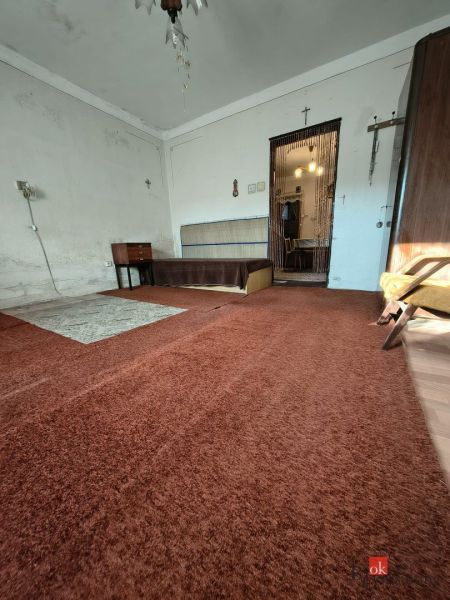 The interior of a family house with older furniture and a brown carpet.