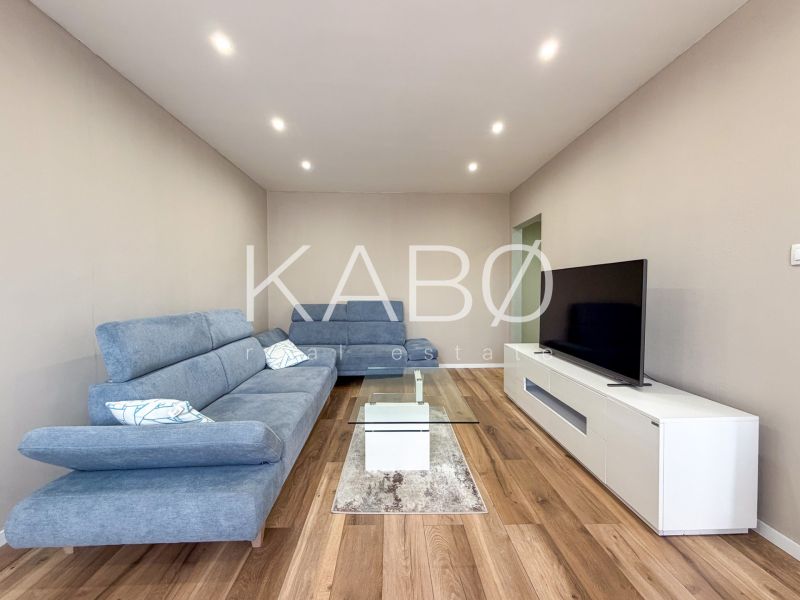 Living room in a two-room apartment with a wooden decor floor and modern furniture.
