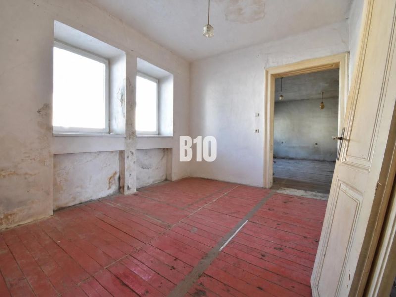 A room in a family house with a wooden floor and simple furnishings.