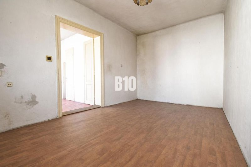A room in a family house with white walls and a wooden decor floor.