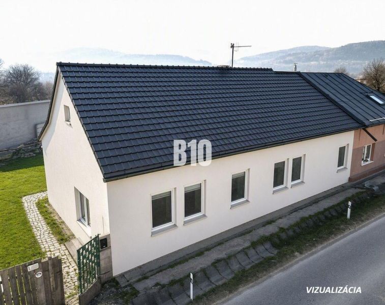 The family house in Bytča has a sloped roof and white facades.