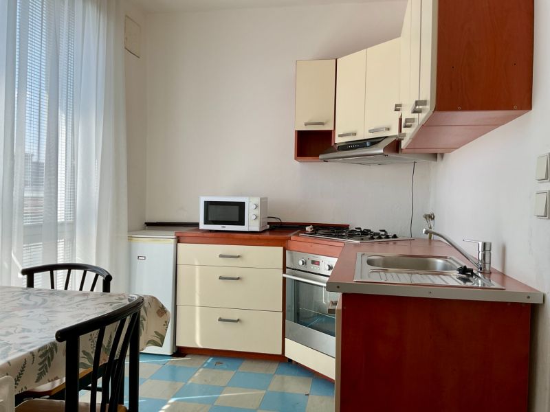 Kitchen in a 2-room apartment with a microwave, stove, and dining table.