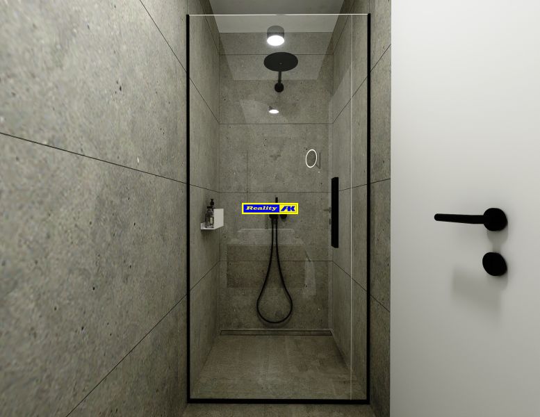 A shower corner with dark tiles and elegant black fixtures in a 3-room apartment.