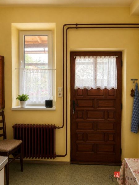 Yellow walls, wooden door, window with white curtains in a family house.