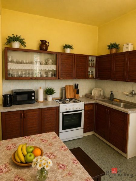 Kitchen of a family house with wooden cabinets, table, and decorations.