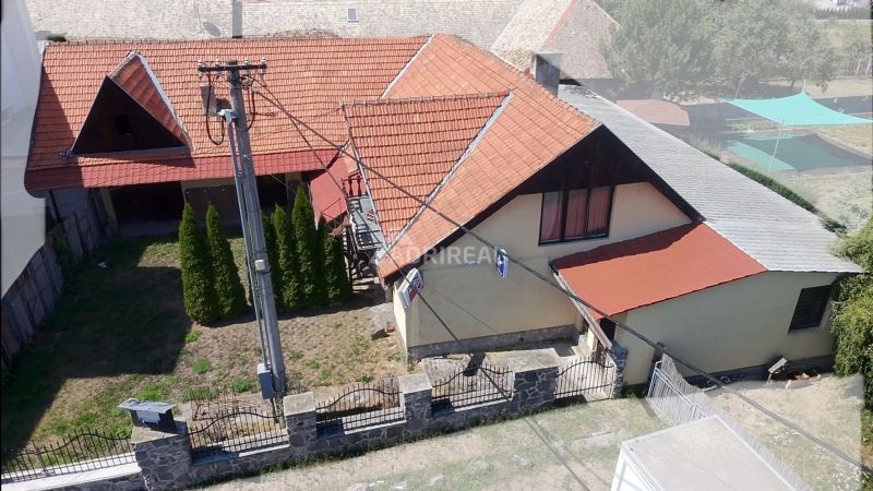A family house in Dobrá Niva with a red roof, a garden, and trees.