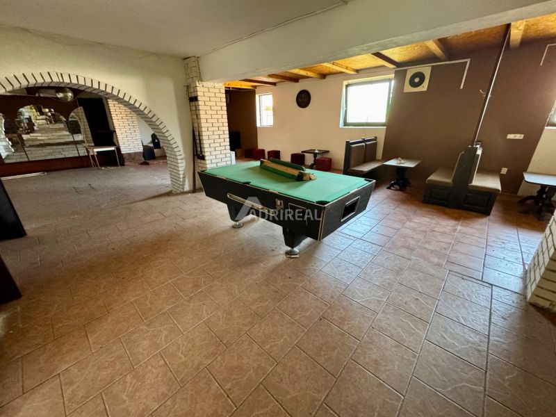 Interior of a family house with a pool table and brick arches.