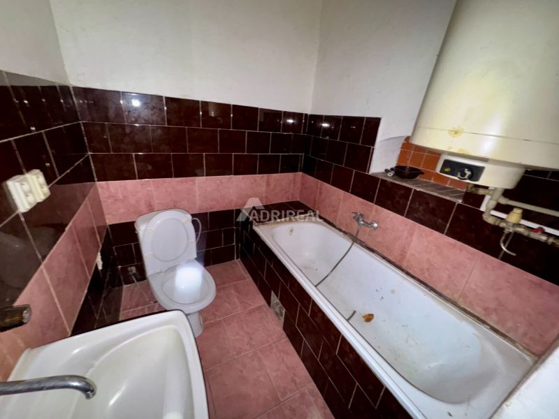 A bathroom in a family house with tiles in shades of pink and brown.