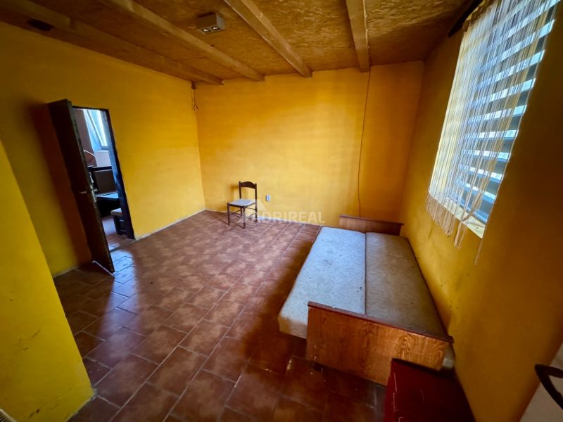 A room in a family house with a wooden decor floor and yellow walls.