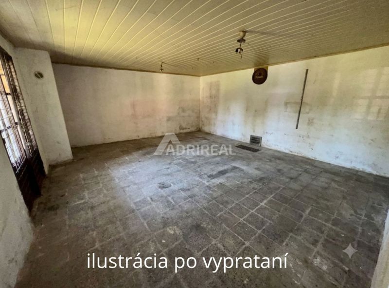 An empty room in a family house with old tiles and white walls.