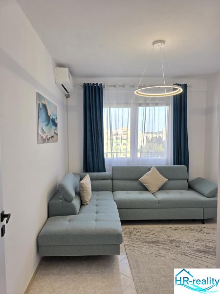 Living room in a 2-room apartment with a comfortable sofa and stylish lighting.