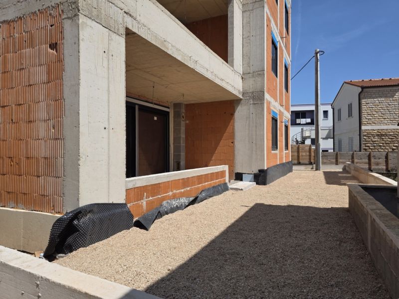 Construction of a 3-room apartment in SRIMA, with an exposed brick facade and a gravel courtyard.