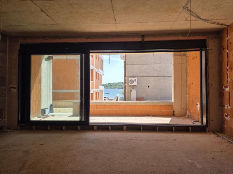 Sea view through a large window in a 3-room apartment in the city of Srima.