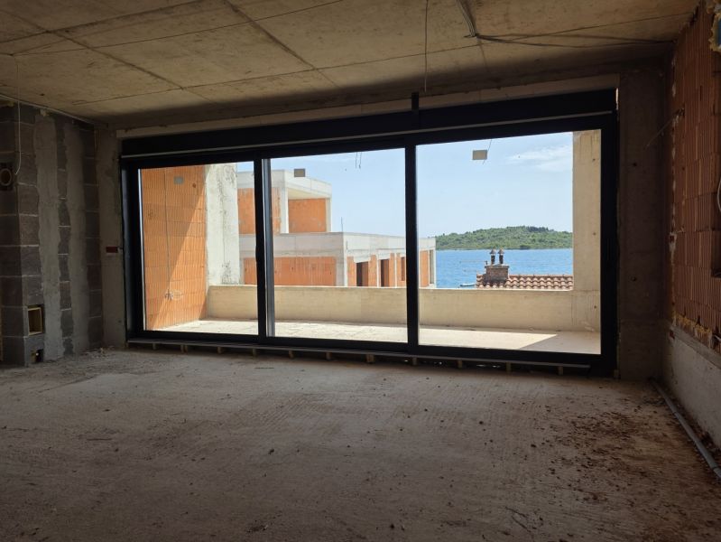 Unfinished interior of a 3-room apartment with a sea view and a balcony.