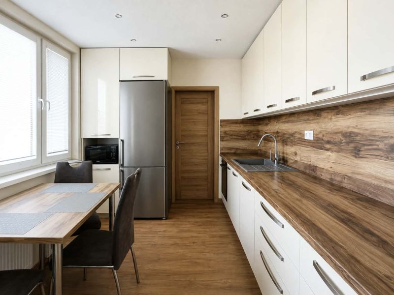 A kitchen in a 3-room apartment with a floor and countertop featuring a wood design.