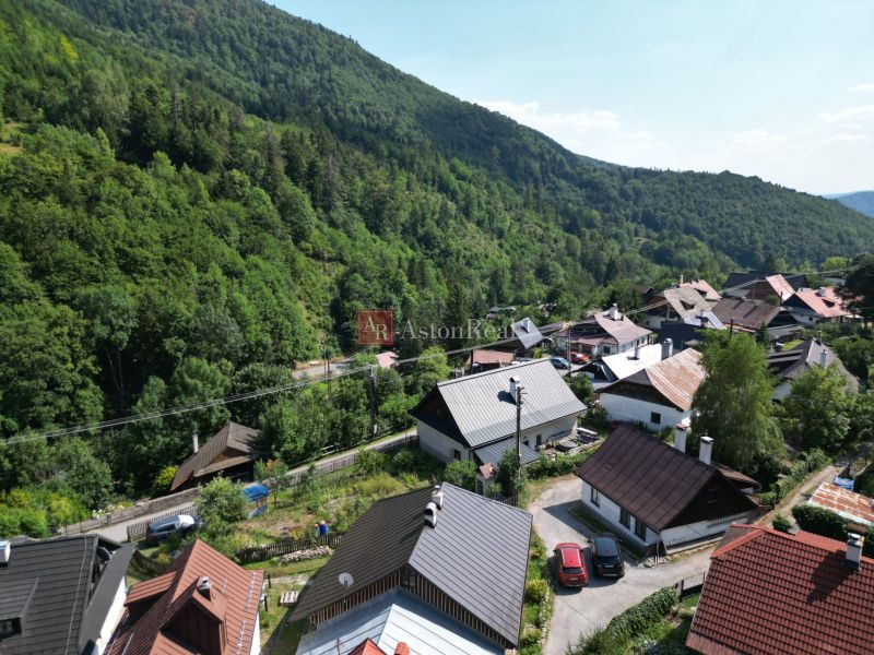 A view of picturesque cottages in Špania Dolina near Banská Bystrica, surrounded by dense forests.
