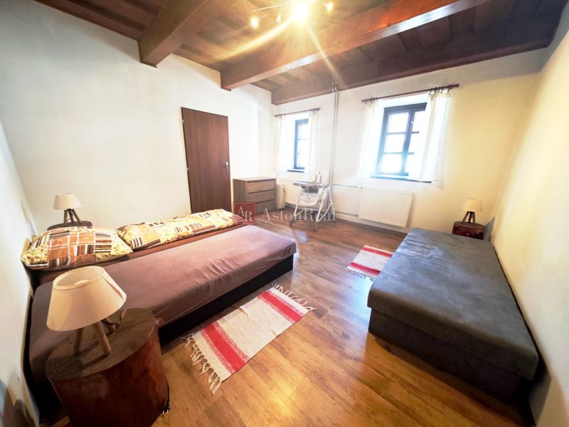 A cabin with two sofas, a floor with a wooden decor, and a wooden ceiling.
