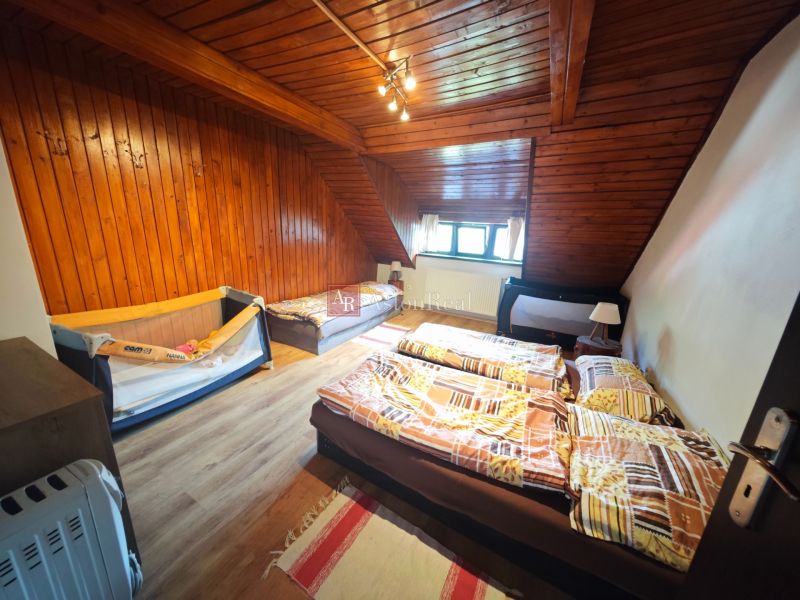 Attic room in a cottage with wooden paneling and a floor with a wooden decor.