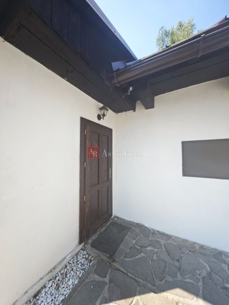 Entrance to the cottage in Špania Dolina with a stone terrace and wooden elements.