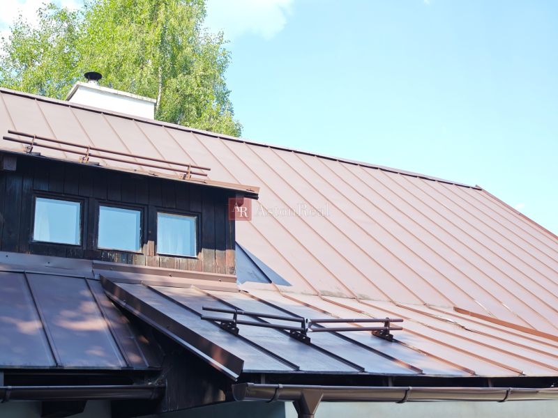 A cottage in Špania Dolina with a tin roof and wooden details.