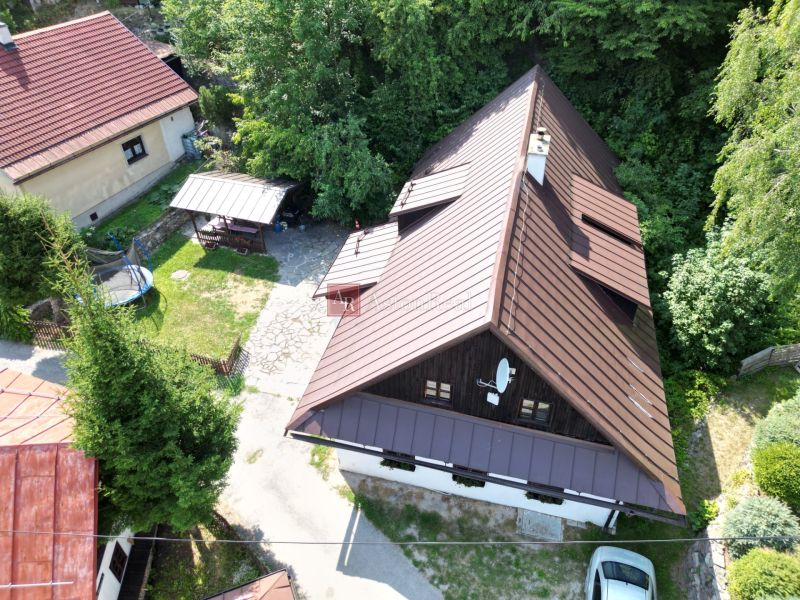 A cottage in Špania Dolina in Banská Bystrica with a yard and greenery in the surroundings.