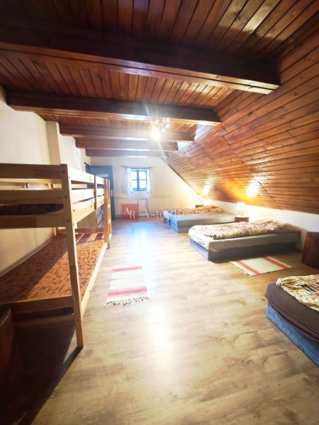 An attic room in a cottage with beds and a wooden decor floor.