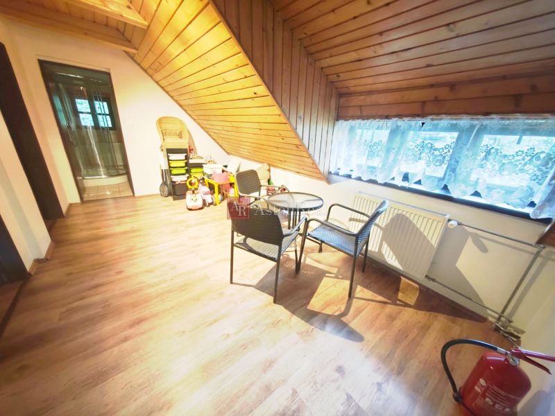 Wooden decor flooring, seating, children's toys, and a sloped ceiling in the cabin.