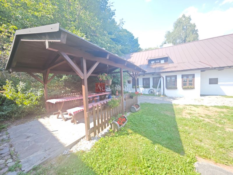 A cottage in Špania Dolina with a gazebo, wooden table, and floral decorations in the garden.