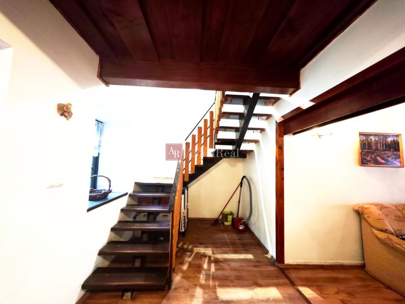 The interior of the cabin with a wooden staircase and a floor with a wooden decor.