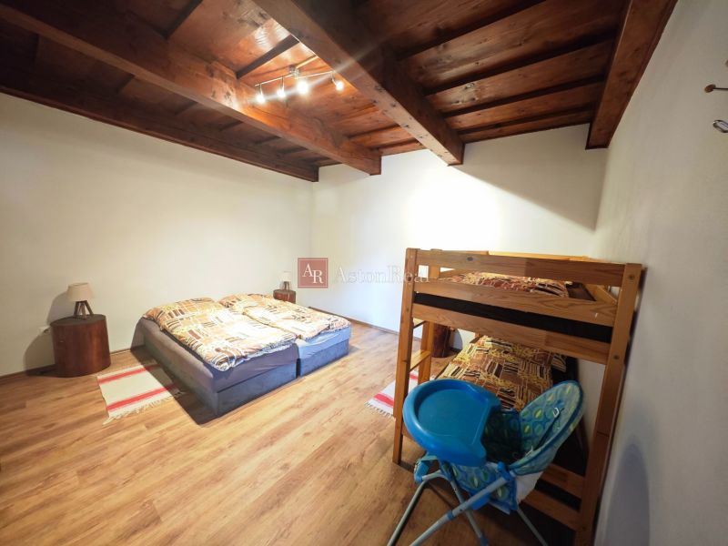 A room in a cottage with a wooden floor and a bunk bed.