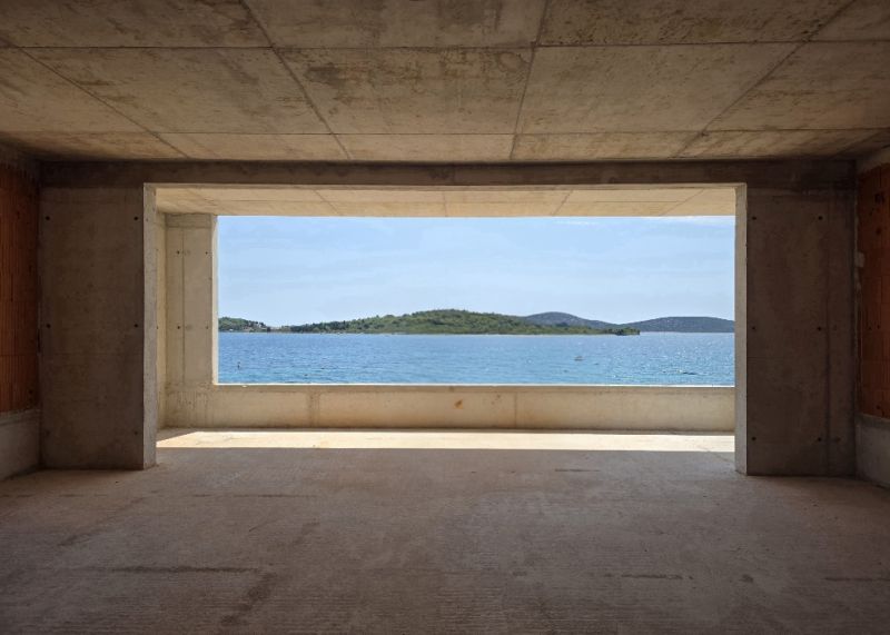 A view from a 4-room apartment of the sea and islands through a large window.
