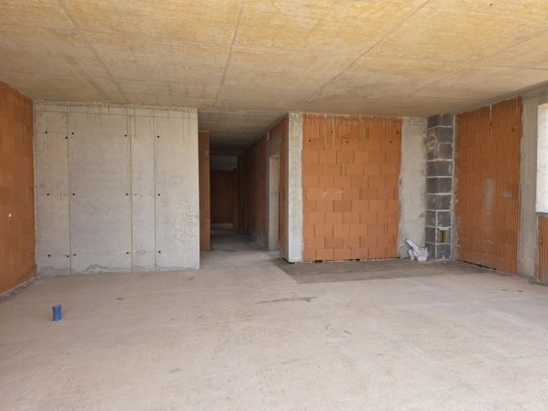 Unfinished concrete and brick walls in a 4-room apartment.