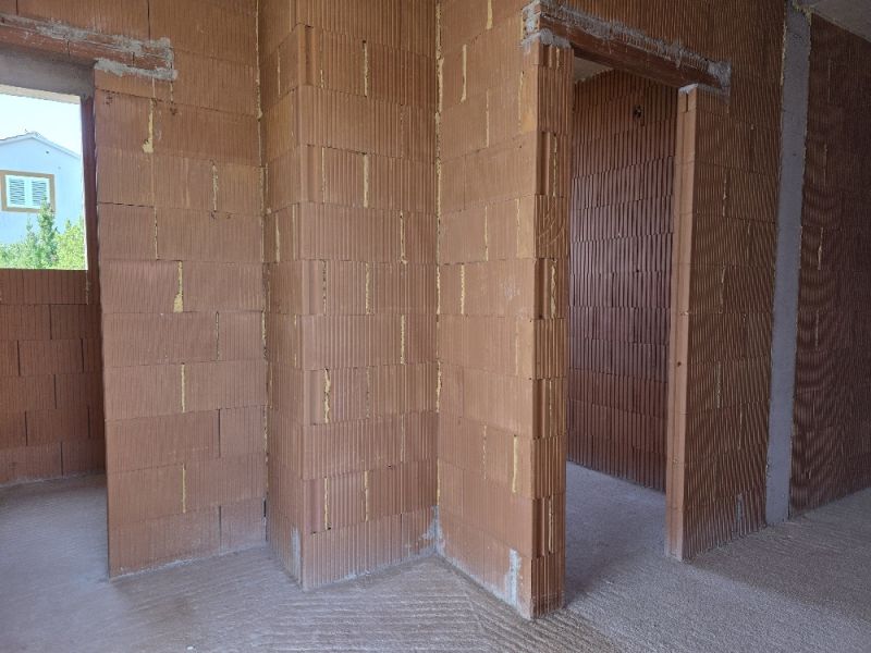 Interior of a 4-room apartment, unplastered brick walls with door openings.