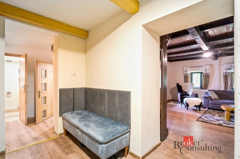 A cottage with cozy seating, a floor with a wooden decor, a view of a comfortable living room.